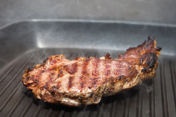 Frying beef steak on a ribbed grill pan — Stock Photo, Image