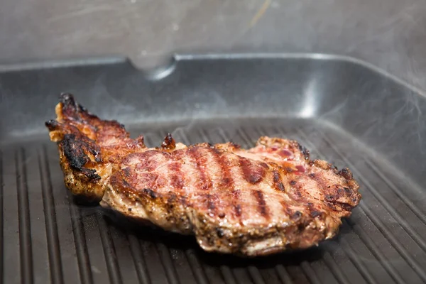 Frying beef steak on a ribbed grill pan — Stock Photo, Image