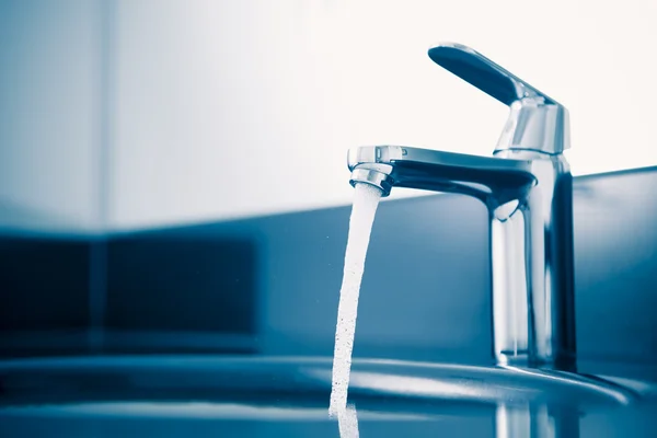 Faucet with flowing water, blue tone — Stock Photo, Image