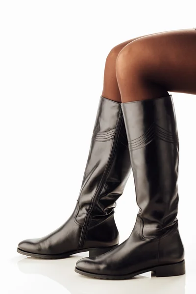 Pernas de mulher vestindo botas de couro preto — Fotografia de Stock