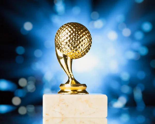 Golfball-Trophäe vor blau glänzendem Funkengrund — Stockfoto