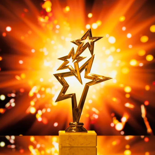 Ouro estrelas troféu contra faíscas brilhantes fundo — Fotografia de Stock