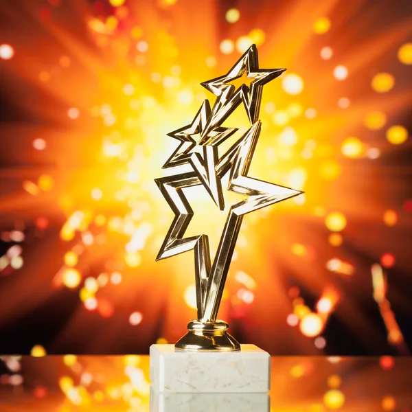 Gold stars trophy against shiny sparks background — Stock Photo, Image