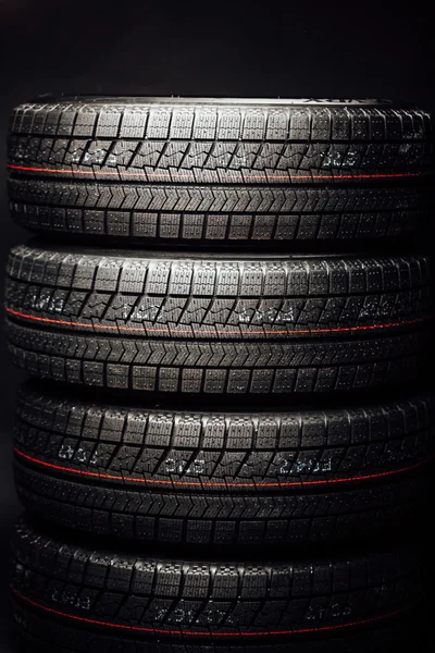 Pile de pneus hiver sans goujons, fond noir — Photo