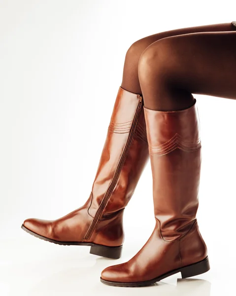 Žena nohy na sobě hnědé kožené vysoké boty — Stock fotografie