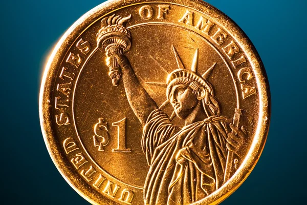 Golden dollar coin on blue background, macro view — Stock Photo, Image
