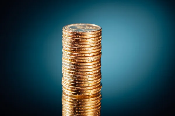 Golden dollar coins stack on blue background — Stock Photo, Image