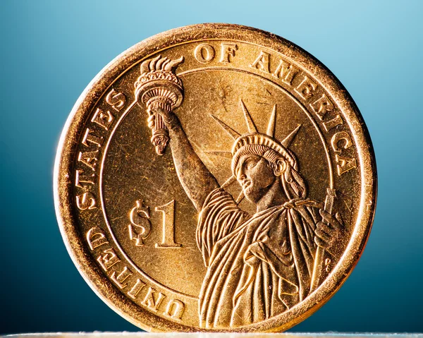 Moeda de dólar dourado no fundo azul, vista macro — Fotografia de Stock