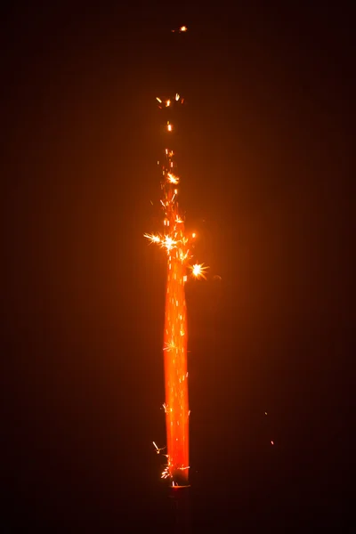 Firework sparkler with orange glow — Stock Photo, Image