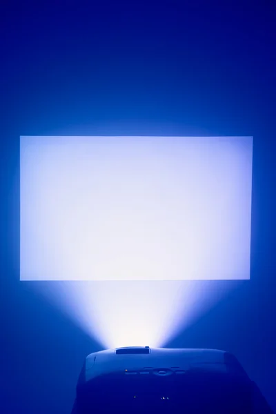 Проектор в дії з освітленим екраном — стокове фото