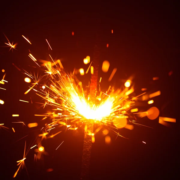 Christmas sparkler in haze with red light — Stock Photo, Image