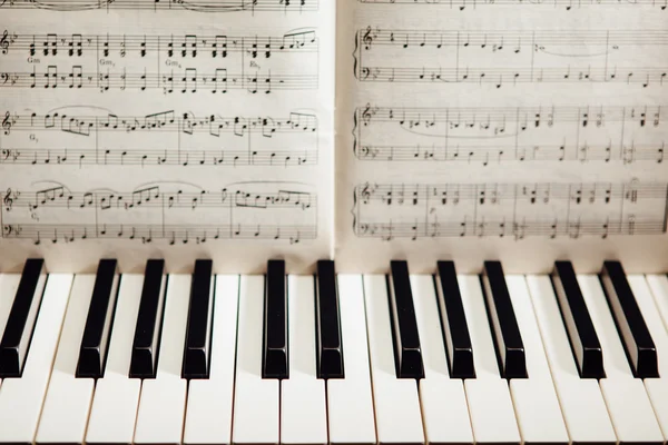 Клавіші піаніно та музична книга — стокове фото