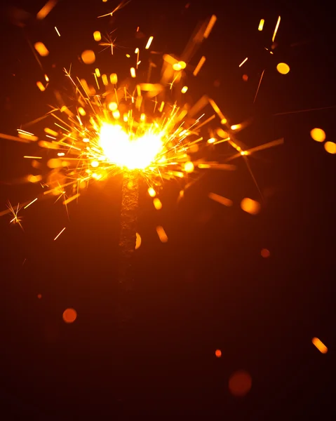 Christmas sparkler in haze with red light — Stock Photo, Image