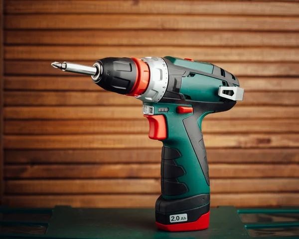 Cordless screwdriver against wooden background — Stock Photo, Image