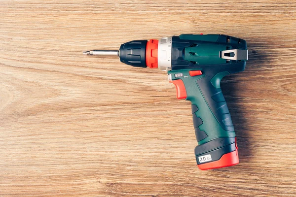 Cordless screwdriver against wooden background — Stock Photo, Image