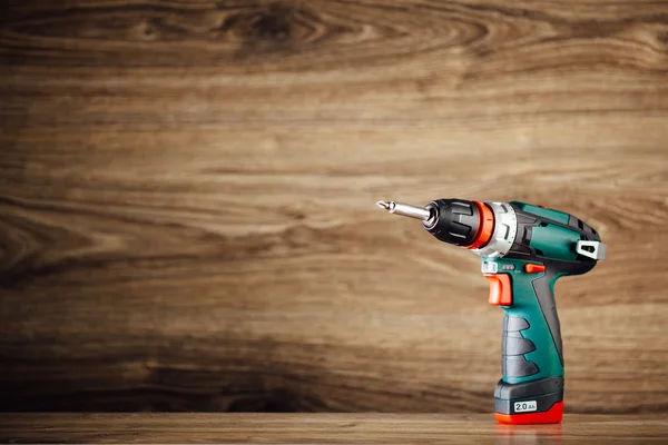 Cordless screwdriver against wooden background — Stock Photo, Image