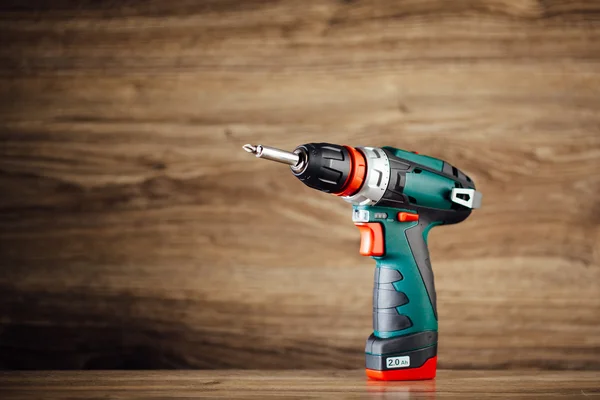 Electric screwdriver against wooden background — Stock Photo, Image