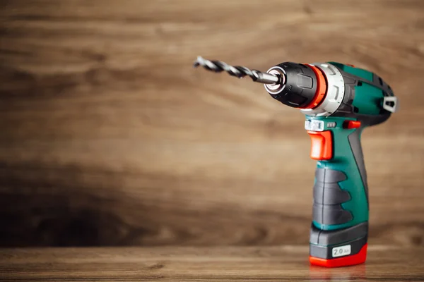 Electric drill against wooden background — Stock Photo, Image