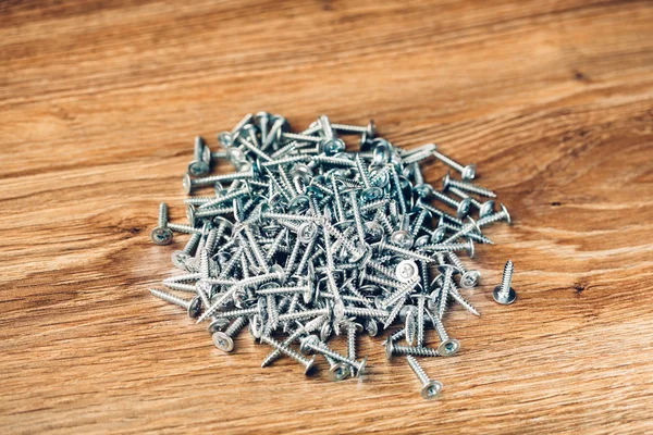 Screws fasteners hardware heap on wooden background — Stock Photo, Image