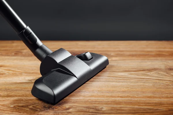 Vacuum cleaner brush on wooden floor — Stock Photo, Image