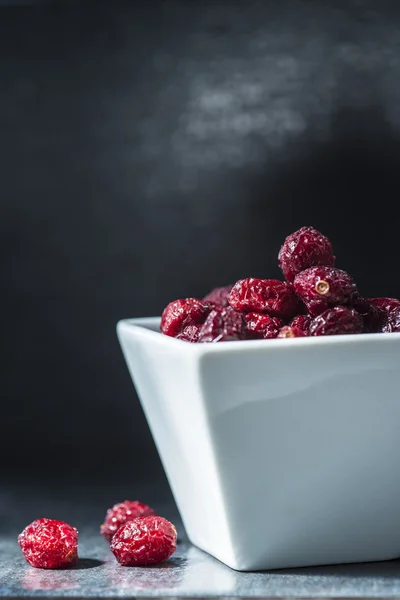 Gedroogde cramberries op een zwarte achtergrond — Stockfoto