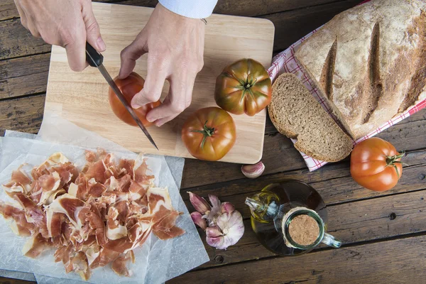 Chef cortando um tomate com uma faca — Fotografia de Stock