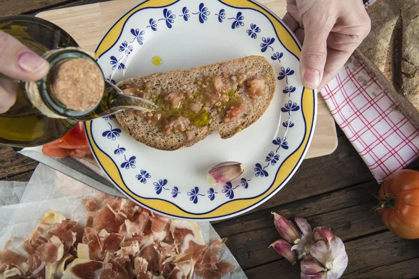 Chef derramando azeite em uma torrada — Fotografia de Stock