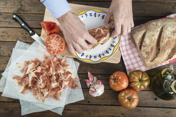 Chef poniendo jamón en una rebanada de pan — Foto de Stock