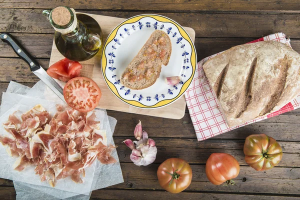 Jamón con pan, tomate, ajo y aceite de oliva — Foto de Stock