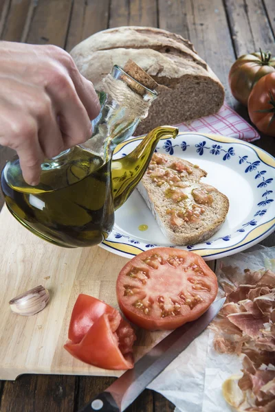 Chef gießt Olivenöl auf einen Toast — Stockfoto