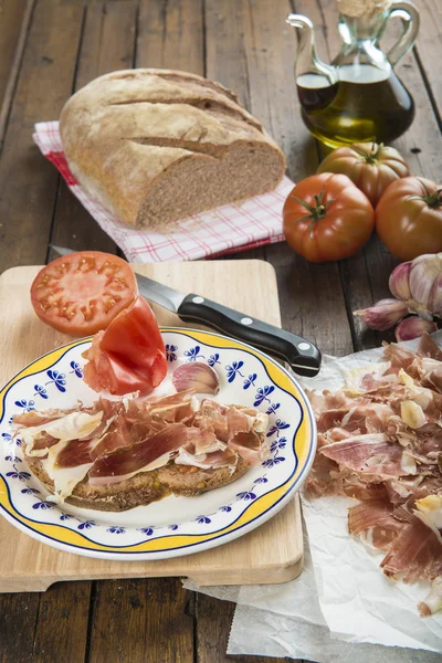 Šunka s chlebem, rajčaty, česnekem a olivovým olejem — Stock fotografie