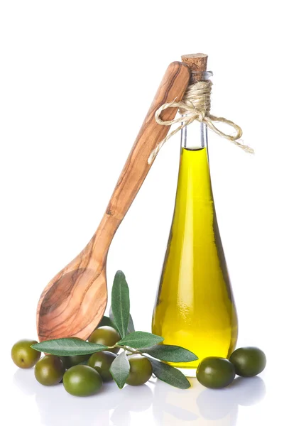 Butelka oliwy z oliwek i drewnianą łyżką na białym tle — Zdjęcie stockowe