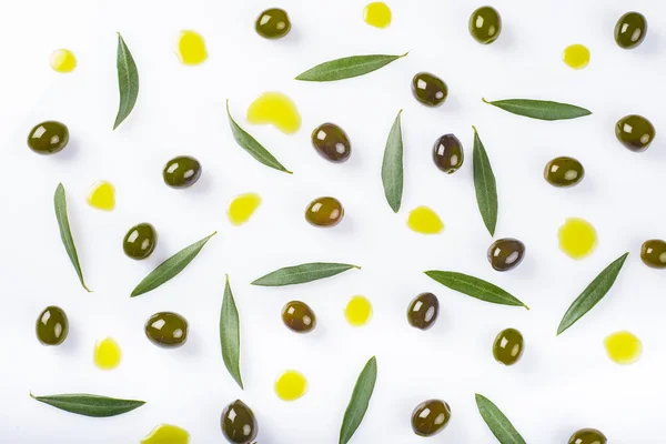 Azeitonas, folhas e gotas de óleo sobre um fundo branco — Fotografia de Stock