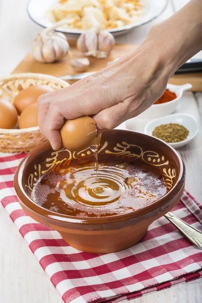 Шеф-повар разбивает яйцо о чесночный суп — стоковое фото