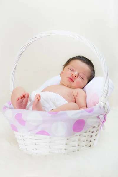 Lykkelig nyfødt pige sover i en kurv - Stock-foto