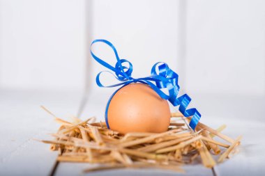 Beyaz ahşap arka planda süslenmiş Paskalya yumurtası.