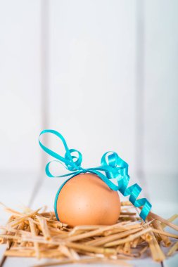 Beyaz ahşap arka planda süslenmiş Paskalya yumurtası.