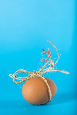 Mavi arka planda bir hediye için dekore edilmiş Paskalya yumurtası.