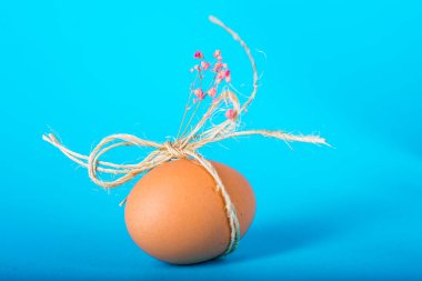 Mavi arka planda bir hediye için dekore edilmiş Paskalya yumurtası.