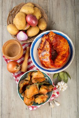 Mutfak masasında patates ve domuz pirzolası bulunan safran süt kapakları.