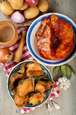 Mutfak masasında patates ve domuz pirzolası bulunan safran süt kapakları.