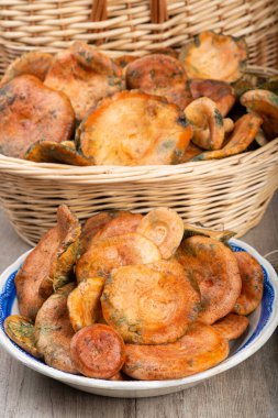 Safran süt kapakları ya da mutfak masasındaki sepet ve kaselerde kırmızı çam mantarları.