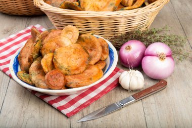 Safran süt kapakları ya da mutfak masasındaki sepet ve kaselerde kırmızı çam mantarları.