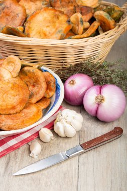 Safran süt kapakları ya da mutfak masasındaki sepet ve kaselerde kırmızı çam mantarları.