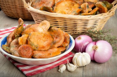 Safran süt kapakları ya da mutfak masasındaki sepet ve kaselerde kırmızı çam mantarları.