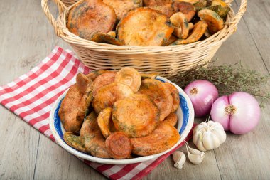 Safran süt kapakları ya da mutfak masasındaki sepet ve kaselerde kırmızı çam mantarları.