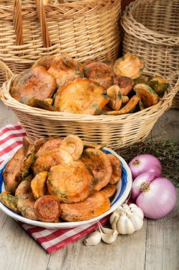 Safran süt kapakları ya da mutfak masasındaki sepet ve kaselerde kırmızı çam mantarları.