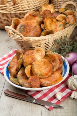 Safran süt kapakları ya da mutfak masasındaki sepet ve kaselerde kırmızı çam mantarları.