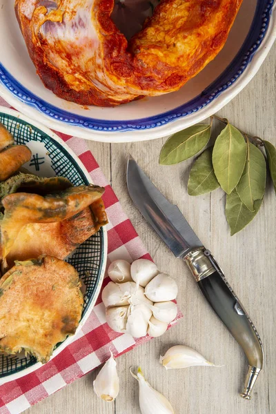 Mutfak masasında patates ve domuz pirzolası bulunan safran süt kapakları.