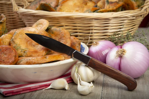 Safran süt kapakları ya da mutfak masasındaki sepet ve kaselerde kırmızı çam mantarları.